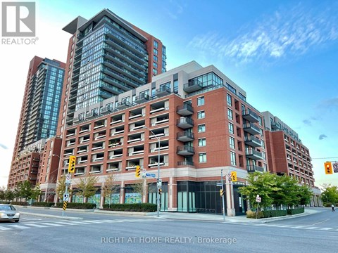 A multi-story building with a glass facade is situated on a street corner.