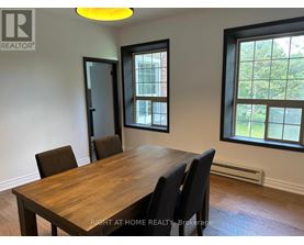 A dining room with a wooden table and chairs.