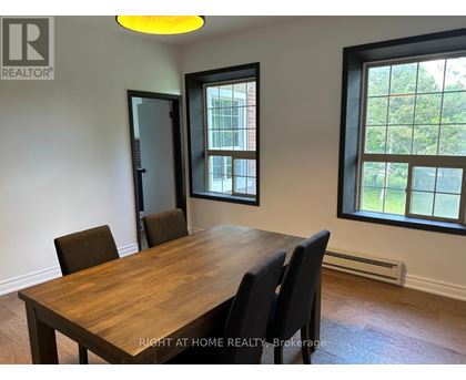 A dining room with a wooden table and chairs.