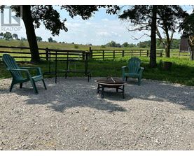 A gravel patio with two green chairs and a table.