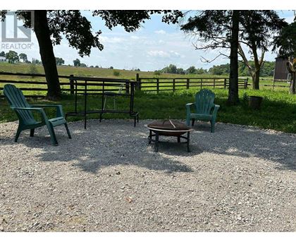 A gravel patio with two green chairs and a table.