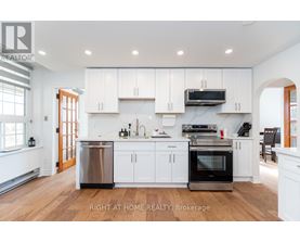 A modern kitchen with white cabinets and stainless steel appliances.