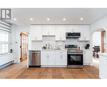 A modern kitchen with white cabinets and stainless steel appliances.