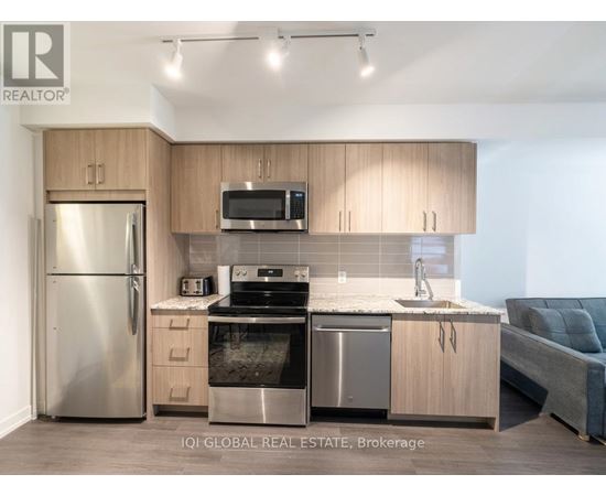 A modern kitchen with stainless steel appliances and wooden cabinets.