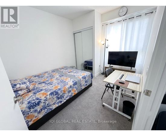 A bedroom with a bed, desk, and chair.