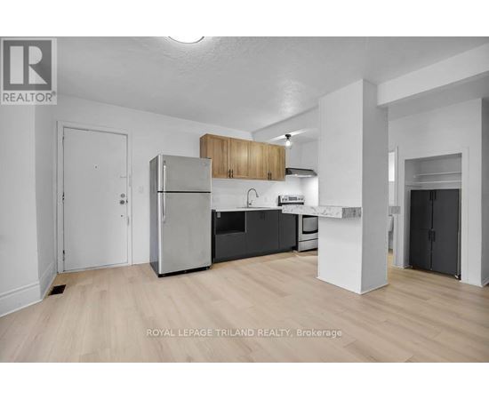 A well-lit, modern kitchen with wooden cabinets and stainless steel appliances.