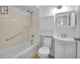 A white bathroom with a tub, toilet, and sink.