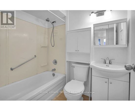 A white bathroom with a tub, toilet, and sink.