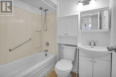 A white bathroom with a tub, toilet, and sink.