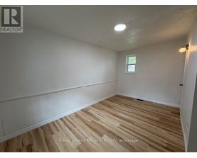 A room with wooden flooring and white walls.