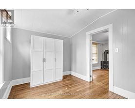 A white room with a wooden floor and a white wardrobe.