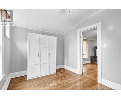 A white room with a wooden floor and a white wardrobe.