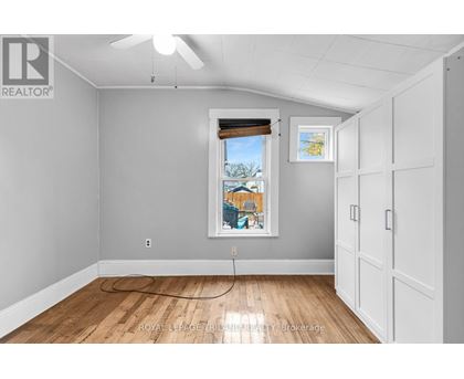 A room with a window and a fan on the ceiling.