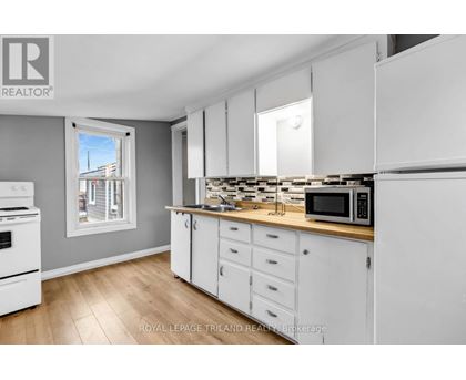 A kitchen with white cabinets and a wooden countertop.