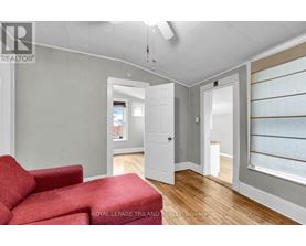 A room with a red couch and a white door.