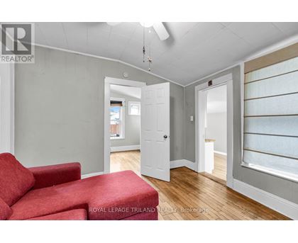 A room with a red couch and a white door.