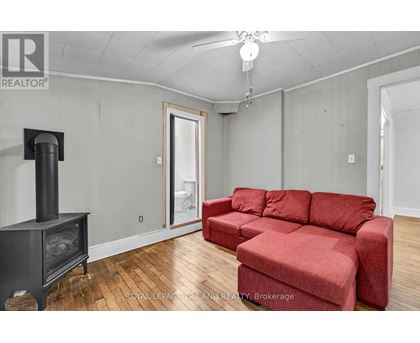 A living room with a red couch and a wood burning stove.