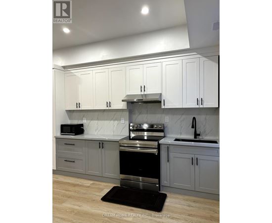A kitchen with white cabinets and a black stove top oven.