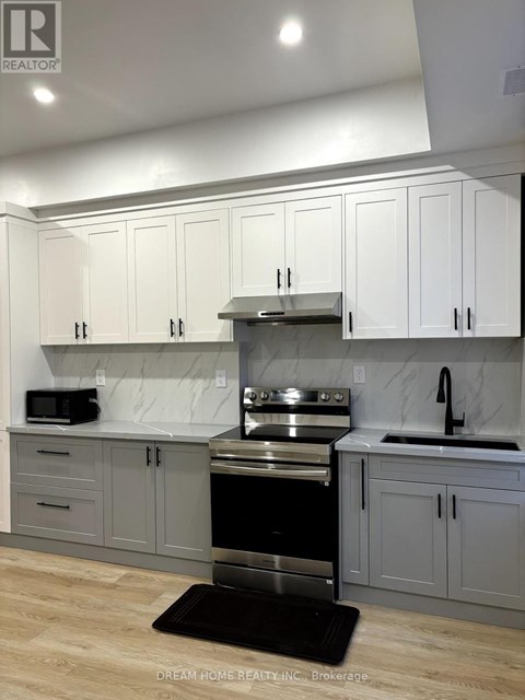 A kitchen with white cabinets and a black stove top oven.