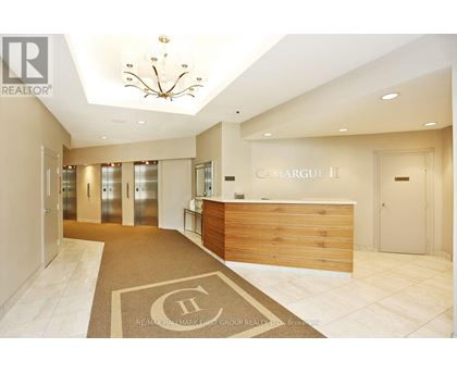 A reception area with a wooden desk and a chandelier.