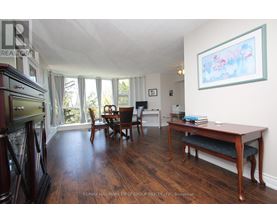 A living room with a wooden floor and a dining table.