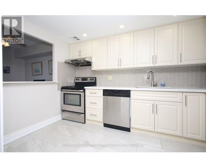 A modern kitchen with white cabinets and stainless steel appliances.