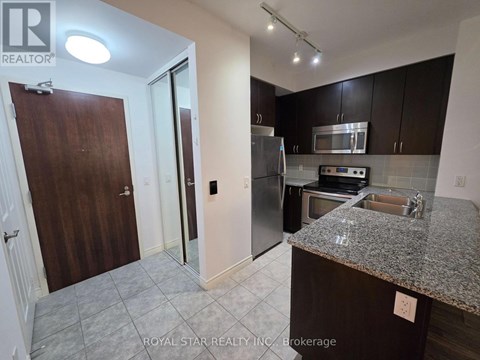 A kitchen with a granite countertop and stainless steel appliances.