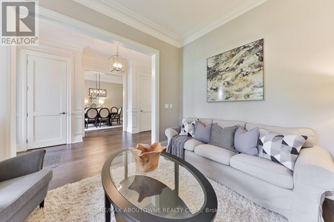 A living room with a grey couch and a large painting on the wall.