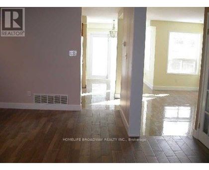 A room with a wooden floor and a doorway leading to another room.