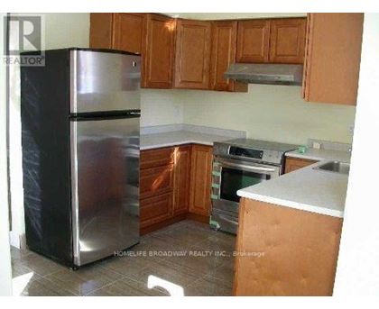 A kitchen with wooden cabinets and a stainless steel refrigerator.