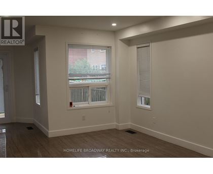 A room with a chandelier and a wall with a logo that says REALTOR.