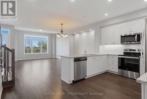 A modern kitchen with white cabinets and stainless steel appliances.