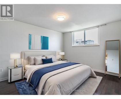 A bedroom with a large bed and a mirror on the wall.