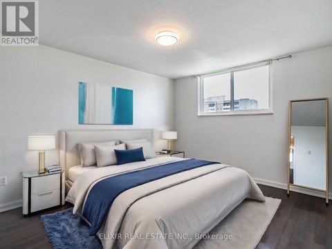 A bedroom with a large bed and a mirror on the wall.