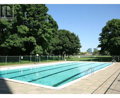 A large outdoor swimming pool surrounded by trees.