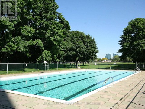 A large outdoor swimming pool surrounded by trees.