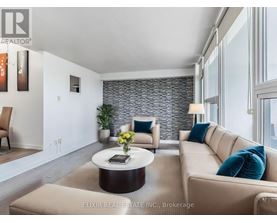 A modern living room with a stone wall and a large window.