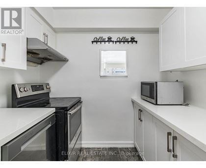 A kitchen with white cabinets and a black stove top oven.