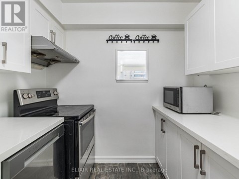 A kitchen with white cabinets and a black stove top oven.
