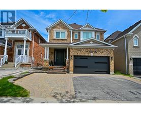 A large brick house with a black garage door in front.