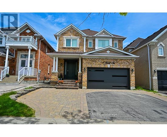 A large brick house with a black garage door in front.