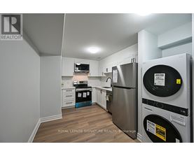 A kitchen with a refrigerator and a washing machine.