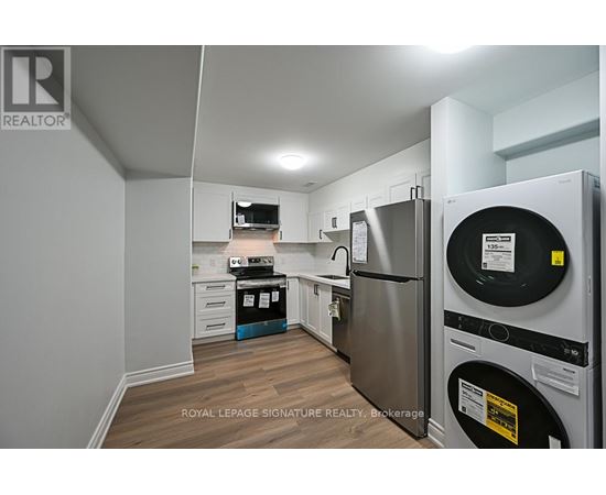 A kitchen with a refrigerator and a washing machine.