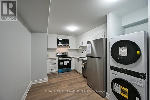 A kitchen with a refrigerator and a washing machine.