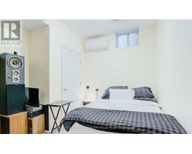 A bedroom with a bed, a table, and a speaker.
