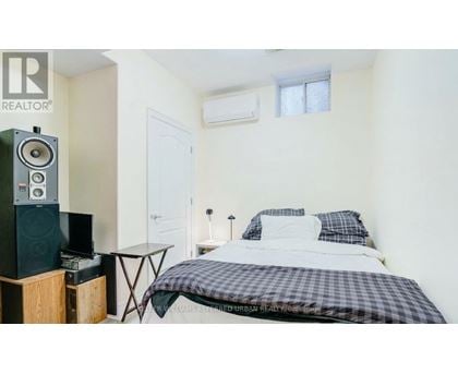 A bedroom with a bed, a table, and a speaker.