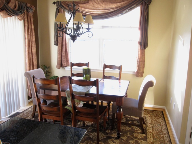 A dining room with a table and chairs.