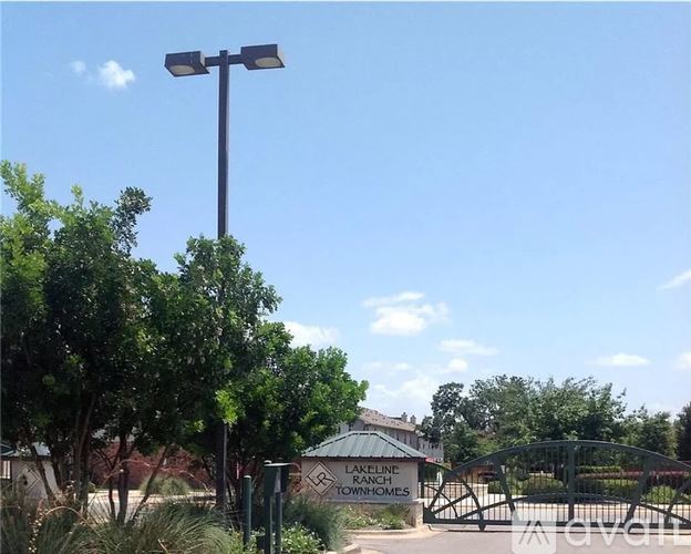 A sign for "Alexline Downhomes" is displayed in front of a gated entrance.