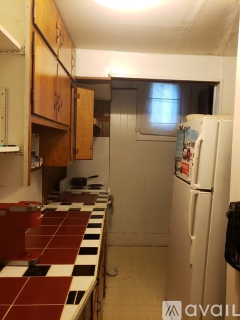 A kitchen with a checkered tile counter and a white fridge.