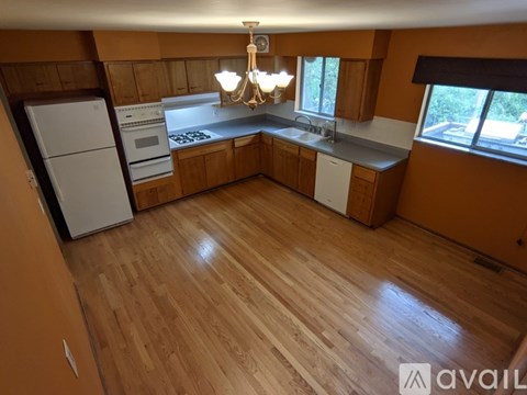 A kitchen with wooden floors and a chandelier.